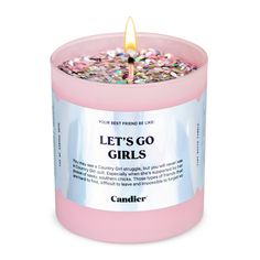 a pink candle that says let's go girls on the front and side with sprinkles in it