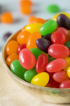 a bowl filled with jelly beans on top of a table