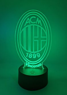 the acm logo illuminated in green on a black base with an acm badge underneath it