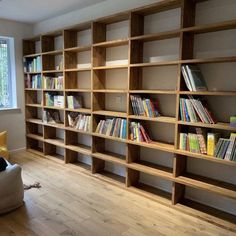 a living room filled with lots of wooden bookshelves