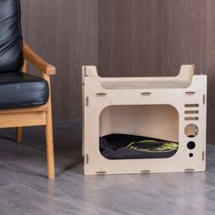 a chair sitting next to a cardboard box with a mattress in it on the floor