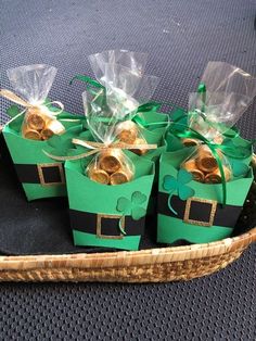 small green boxes with gold coins in them sitting on a basket filled with other items