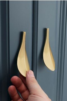 a hand is holding the door handle to an open door with a gold leaf design on it