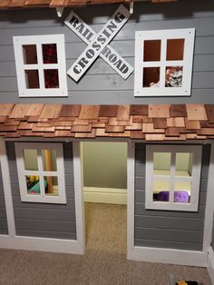 a toy house made out of wood with windows on the roof and doors open to allow children to play outside