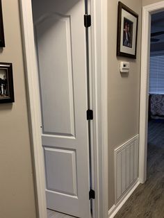 an open door leading to a bedroom with pictures on the wall