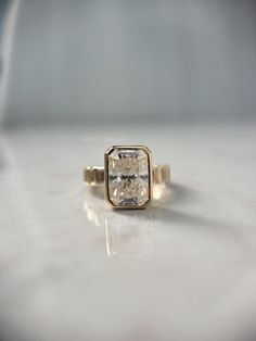 a gold ring with a square cut diamond