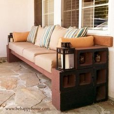 a couch sitting on top of a stone floor next to a window