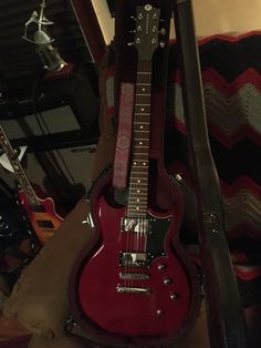 a red electric guitar sitting on top of a case