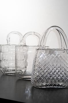 four clear glass baskets sitting on top of a table