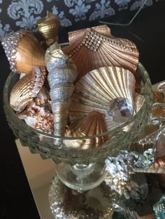 a glass bowl filled with seashells on top of a table