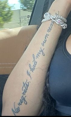 a woman with a tattoo on her arm is sitting in a car