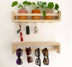 three wooden shelves holding sunglasses, plants and keychains on top of each shelf