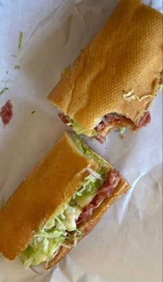 a sandwich cut in half sitting on top of paper