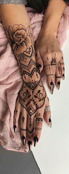 a woman's hands with tattoos on them