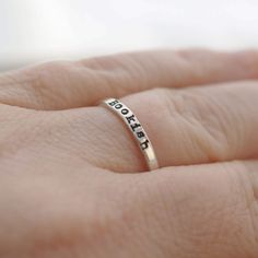 a person's hand with a ring that says, love is in the air