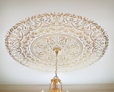 a chandelier hanging from the ceiling in a room with white walls and flooring