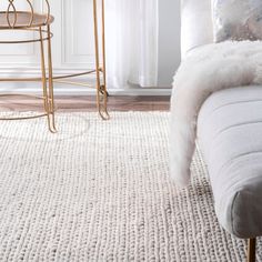 a living room with a couch, chair and rug in white colors on the floor