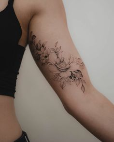 a woman's arm with a flower tattoo on the left side of her body