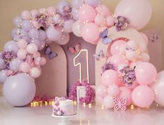 a table topped with balloons and a cake