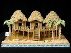 a model of a house made out of straw and palm trees