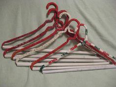 four pairs of scissors are lined up on a bed with red and white yarns