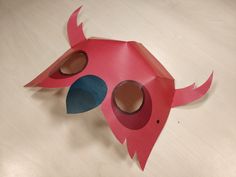 a pink paper mask with holes in it