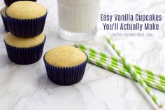 three vanilla cupcakes sitting on top of a counter next to two green and white straws