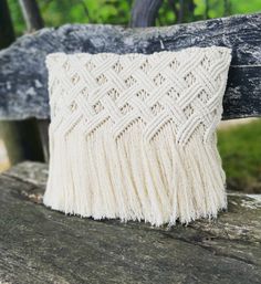 a white pillow sitting on top of a wooden bench