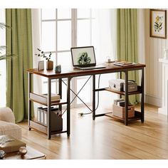 a computer desk in front of a window with green curtains