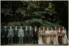 a group of people standing next to each other in front of trees