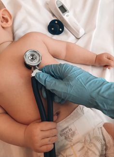 a baby laying on top of a bed with a stethoscope in his hand