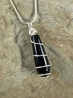 The classic beauty of this long smooth rounded teardrop black onyx necklace is stunning. The deep black color of the stone is beautiful in its simplicity. I chose to enhance this gorgeous gem with a minimalist spiral silver wire design to let the natural beauty shine. In addition to its appearance, did you know black onyx is a powerful protection stone? It is said to absorb and transform negative energy, promoting emotional and physical strength during times of stress. It is also an alternate bi Minimalist Black Wire Wrapped Necklace, Black Oval Pendant Minimalist Jewelry, Minimalist Black Teardrop Pendant Necklace, Minimalist Black Oval Pendant Jewelry, Black Onyx Pendant, Physical Strength, Wire Design, Onyx Pendant, Black Onyx Necklace