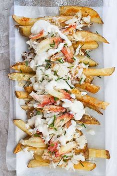 french fries covered in white sauce and garnished with fresh herbs