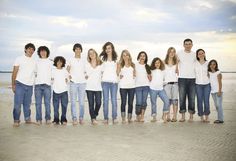 a group of people standing next to each other on a beach