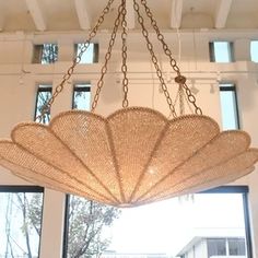 a chandelier hanging from the ceiling in a room with large windows and white walls