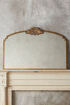 a mirror sitting on top of a mantle next to a fire place