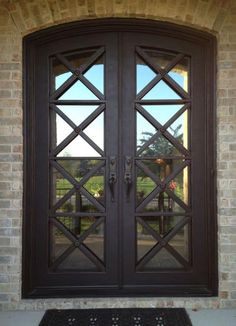 the front door to a house with two glass doors on each side and an arched window above it