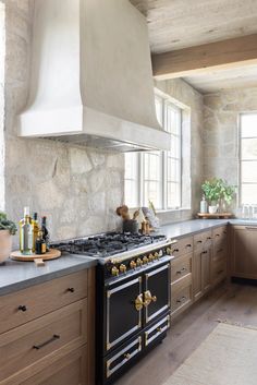 a stove top oven sitting inside of a kitchen next to wooden cabinets and counter tops