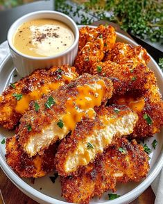 some fried food on a white plate with dipping sauce