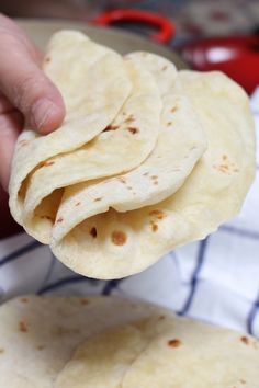 a person is holding some tortillas in their hand