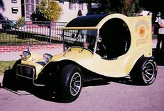 an old yellow car is parked on the street