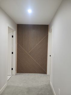 an empty room with white walls and carpeted flooring on the wall is decorated with wood strips