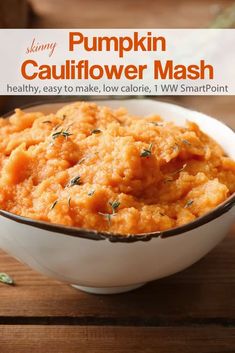 pumpkin cauliflower mash in a white bowl on top of a wooden table