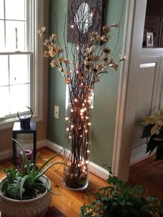 a vase filled with lots of flowers on top of a wooden floor next to a window