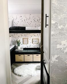 an open door leading to a bedroom with white and black wallpaper on the walls