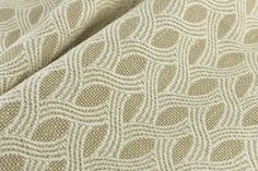 a close up view of a beige fabric with wavy lines and circles on the side