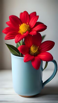 two red flowers are in a blue mug