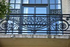 a balcony with wrought iron railing and windows