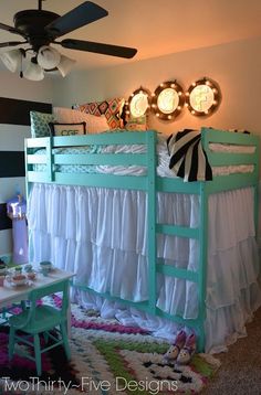 a bedroom with a bunk bed, desk and ceiling fan