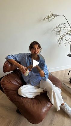 a man sitting on a bean bag chair holding a cup